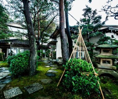 Stone lantern and mossy stepping path through pine garden at Yamanoo, Ishikawa