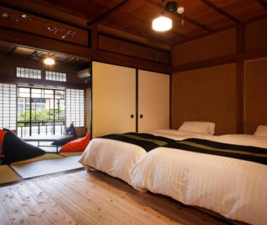 Tatami seating area and two beds at Yamasaki Ryokan Q Nakamonzenya Hyōgo Kansai