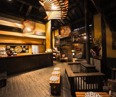 Wooden reception and seating area with hanging lanterns and cushions at Yamashinobu, Kumamoto, Kyūshū