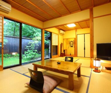 Traditional tatami room with low table, zabuton, shoji screens and garden view at Yamashinobu, Kumamoto