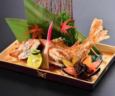 Whole fried fish with citrus and assorted garnishes on lacquer tray at Yamashiro Onsen Miyabi no Yado, Ishikawa