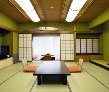 Traditional Japanese tatami room with low table, shoji screens and tokonoma at Yamashiro Onsen Yuzankaku in Ishikawa