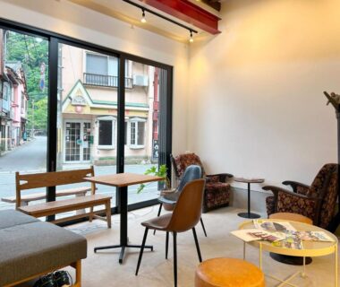 Modern lounge with mixed seating, low tables and large window at Yamatoya in Hyōgo