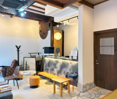 Reception area with seating, wooden counter and coat stand at Yamatoya, Hyōgo, Kansai