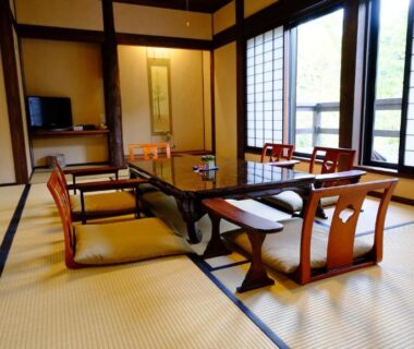 Tatami room with low table, zaisu chairs, shoji screens and sliding doors at Yamazatonoiori Soene in Gifu