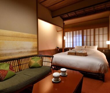 Japanese-style room with bed, low table, sofa and shoji screens at Yasaka Yutone Kyokoyado Kyoto