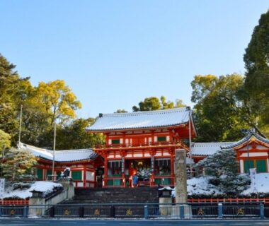 Red shrine facade with stone steps and light snow at Yasaka Yutone Kyokoyado Kyoto Kansai Japan