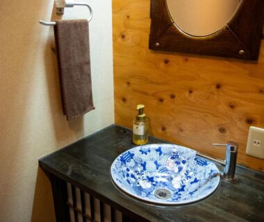 Blue floral ceramic sink on wooden vanity at Yasuraginoyado Yufu in Ōita, Kyushu