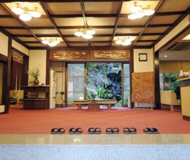 Traditional ryokan entrance with lined slippers, reception desk and inner garden at Yokikan in Shizuoka