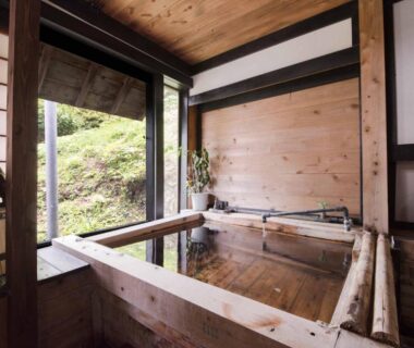 Wooden indoor onsen bath with large window overlooking hillside at Yokohama Fujiyoshi Izuten, Shizuoka