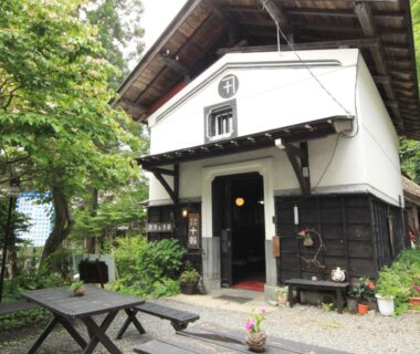 White kura-style entrance with outdoor seating at Yokokura Ryokan in Nagano, Chūbu Japan