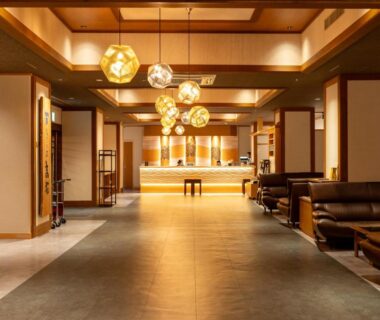 Spacious ryokan lobby with pendant lights, seating and reception at Yorokobinoyado Takamatsu, Gunma