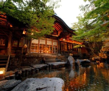 Evening lanterns by reflecting pond and wooden facade at Yorozuya, Nagano, Chūbu, Japan