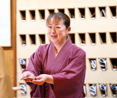 Ryokan staff in kimono at reception with wooden shoe lockers, Yorozuya, Nagano