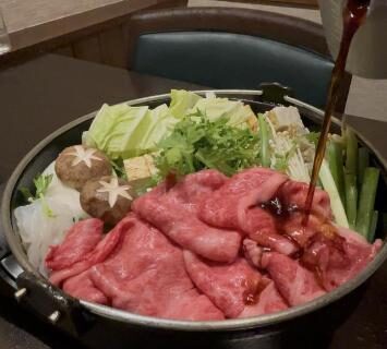 Sukiyaki pot with sliced beef and vegetables at Yoshidaya Ryokan in Nara