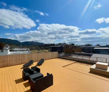 Sunlit rooftop terrace with lounge chairs and mountain views at Yoshidaya Ryokan, Nara, Kansai
