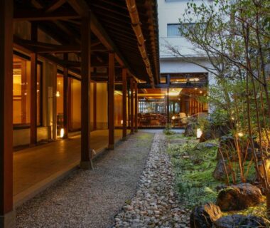 Covered wooden corridor and gravel path beside a lantern-lit courtyard garden at Yoshidaya Ryokan Nara