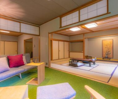 Spacious tatami room with low table, shoji screens and seating at Yoshiike Ryokan in Kanagawa
