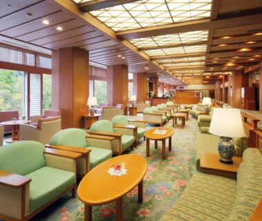 Long lounge with green armchairs and low tables at Yoshikawaya in Fukushima, Tōhoku