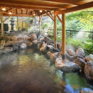 Rock-lined onsen bath with wooden canopy at Yoshikawaya in Fukushima Tōhoku