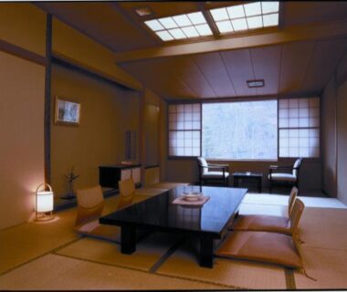 Tatami room with low wooden table, floor cushions, shoji screens and window seating at Yoshikawaya Fukushima