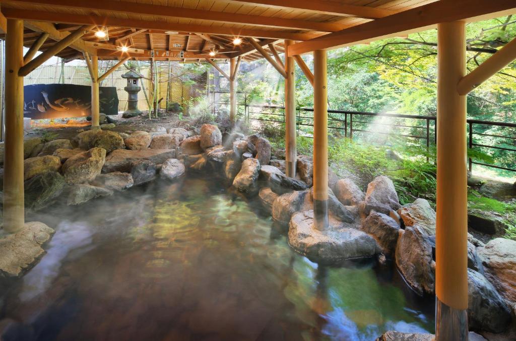 Rock-lined onsen at Yoshikawaya Fukushima Rock-lined onsen bath with wooden canopy at Yoshikawaya in Fukushima Tōhoku