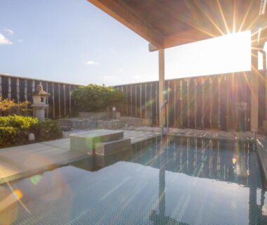 Sunlit outdoor onsen bath with wooden decking at Yoshino Ryokan in Shizuoka Chūbu