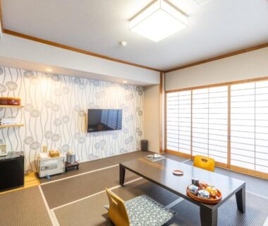 Tatami room with low table, shoji screens and TV at Yoshino ryokan in Shizuoka, Chūbu, Japan