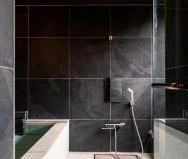 Indoor tiled bath with handheld shower and stone tubs at Yoshino, Shizuoka, Chūbu, Japan
