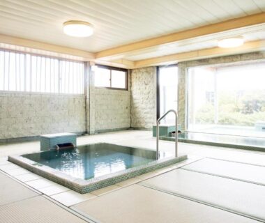 Sunken indoor onsen with tatami flooring and large window at Yoshino ryokan in Shizuoka Chūbu