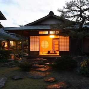 Evening view of a lit shoji facade and stone garden path at Yoyokaku in Saga, Kyushu