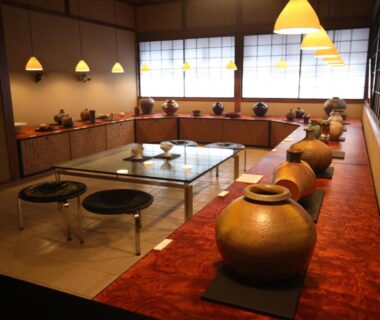 Traditional tatami seating room with low table, ceramic jars, shoji screens and pendant lamps at Yoyokaku, Saga