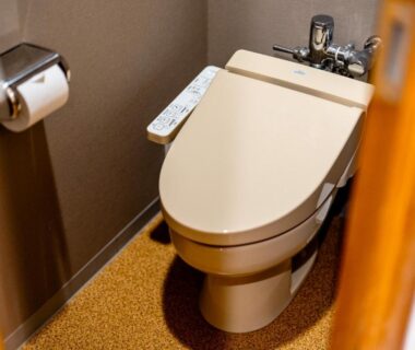 Modern Japanese toilet with bidet control and paper holder in a compact stall at YuYu Hakone Kanagawa Japan