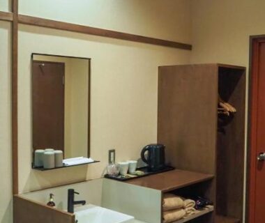 Sink with mirror, wooden shelves, kettle and mini fridge in YuYu Hakone ryokan wash area, Kanagawa, Japan