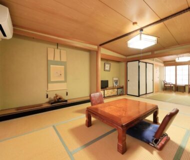 Tatami room with low table, zabuton chairs and shoji screens at Yudanaka Seifuso in Nagano
