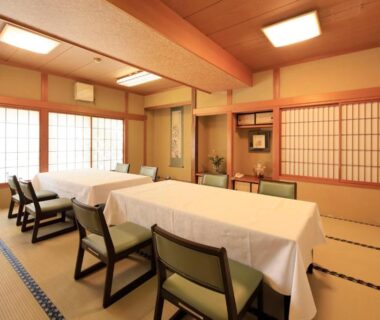 Tatami dining room with covered tables, chairs, shoji screens and wooden beams at Yudanaka Seifuso Nagano