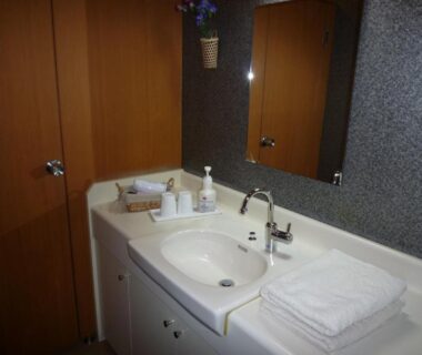 Sink and vanity with folded towels, soap dispensers and mirror in Yudanaka Tawaraya Ryokan bathroom, Nagano