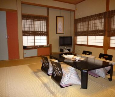 Traditional tatami room with low table, zaisu chairs, shoji screens and bamboo blinds at Yudanaka Tawaraya Ryokan Nagano