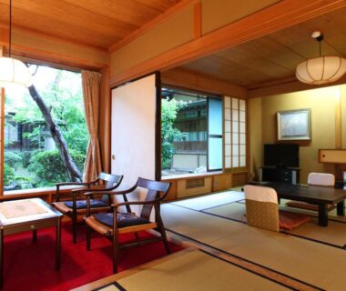 Tatami room with low table, shoji screens and garden view at Yudanaka Yumoto in Nagano, Chūbu