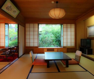 Traditional tatami room with low dining table, shoji screens and garden view at Yudanaka Yumoto, Nagano