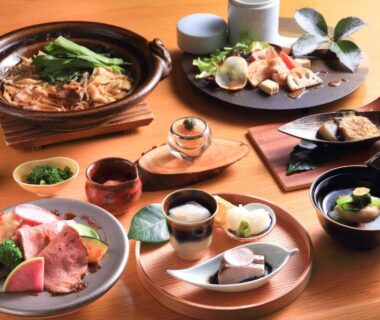 Selection of small plated Japanese dishes on wooden table at Yufudake Ichibo no Yado Kirara, Ōita