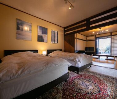 Interior tatami room with twin beds, shoji screens and seating area at Yufuin Bath Satoyamasafu in Oita, Kyushu
