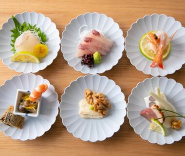Six scalloped plates of sashimi and seafood appetizers at Yufuin Bath Satoyamasafu in Ōita, Kyūshū