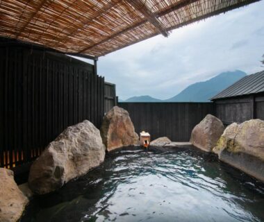 Rock-lined outdoor onsen with mountain view at Yufuin Bath Satoyamasafu in Ōita, Kyūshū