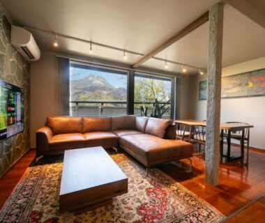 Sectional sofa and coffee table by window with mountain view at Yufuin Kaze no Mori, Ōita, Kyūshū