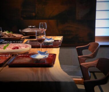 Dining table with Japanese dishes and wine glasses at Yufuin Kaze no Mori in Ōita, Kyūshū