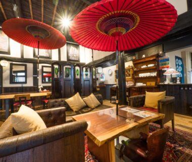 Cozy wooden lounge with red paper umbrellas at Yufuin Lamp no Yado in Ōita, Kyushu
