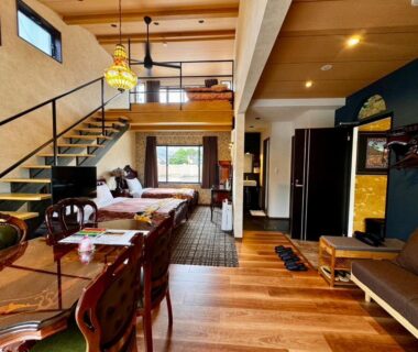 Loft room with wooden floors, dining table and sofa at Yufuin Lamp no Yado in Ōita, Kyūshū