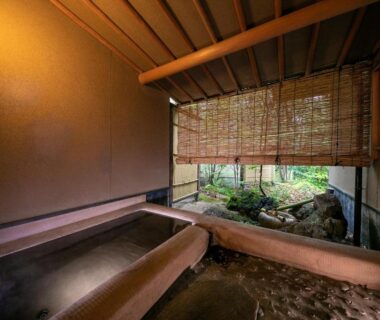Wooden onsen bath with bamboo blinds overlooking courtyard garden at Yufuin Hinoharu Ryokan, Oita, Kyushu