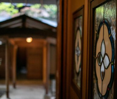 Stained glass door panels and wooden corridor at Yufuin Onsen Hinoharu Ryokan, Ōita